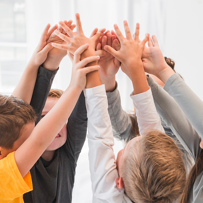 Niños jugando levantando las manos